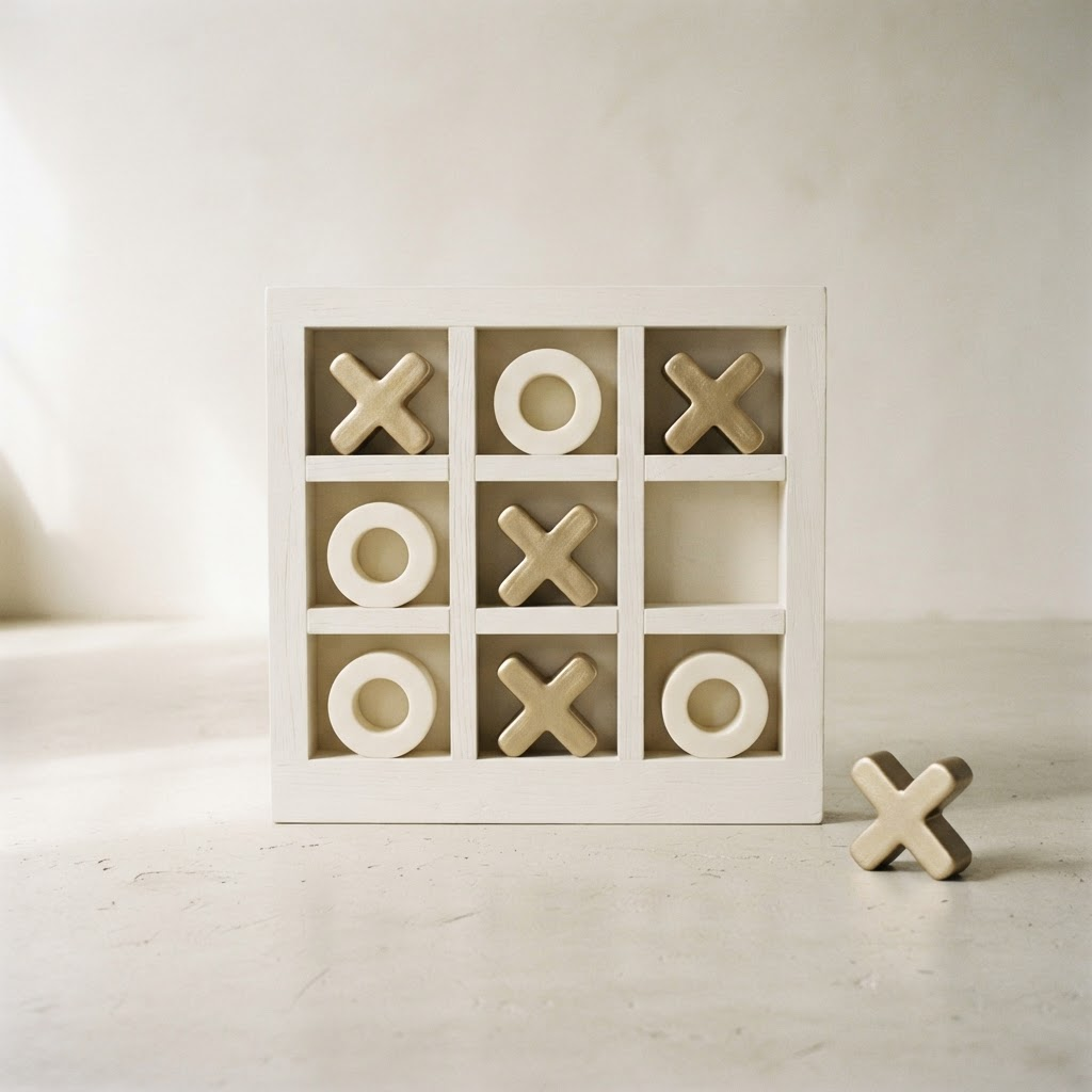 Giant white noughts and crosses frame with ivory and champagne gold pieces on an ivory studio background